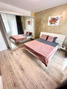 - une chambre avec 2 lits et un miroir dans l'établissement Mega Rossa Residence, à Bucarest