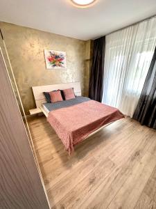 - une chambre avec un lit et du parquet dans l'établissement Mega Rossa Residence, à Bucarest