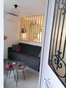 uma sala de estar com um sofá e uma mesa em Nina’s Garden em Loutraki