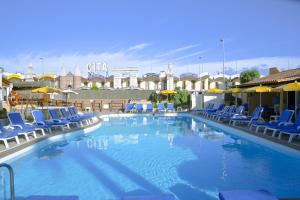 a large swimming pool with blue chairs and umbrellas at Bungalows Los Almendros - Exclusive Vacation Club in Playa del Ingles