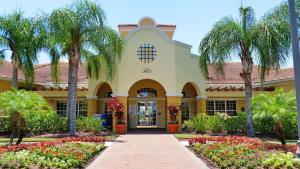 a building with palm trees and flowers in front of it at Resort Townhome: Perfect Orlando Vacation Spot in Orlando