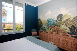 een slaapkamer met een groot raam en een schilderij aan de muur bij Appartement 5 min des plages Croisette in Cannes