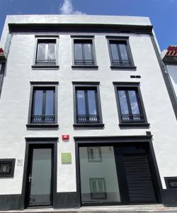 a white building with black windows at Olive Boutique Guesthouse in Vila Franca do Campo