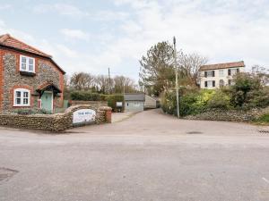 a house with a stone wall and a driveway at 14 The Dell in Norwich