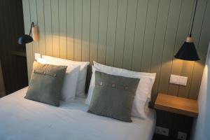 a bedroom with a bed with white sheets and pillows at Olive Boutique Guesthouse in Vila Franca do Campo