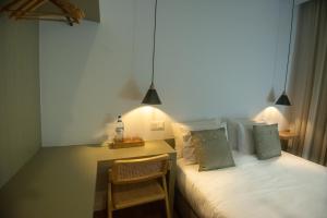 a bedroom with a bed and a table with a chair at Olive Boutique Guesthouse in Vila Franca do Campo