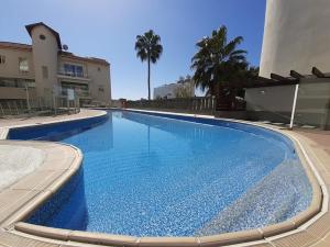 a large blue swimming pool next to a building at Anamor apartment 408 in Larnaka