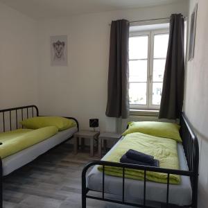 1 dormitorio con 2 camas y ventana en IMBACH KLOSTERHOF -Ferienapartments im Herzen der Wachau, en Imbach