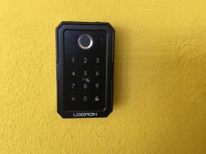 a black remote control on a yellow wall at Foothills Apartment 28 Vacation Nest in San Fernando