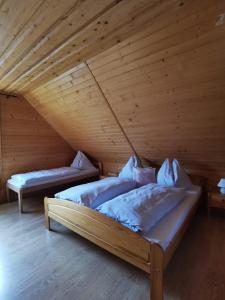 two beds in a room with wooden ceilings at Drevenica Západné Tatry in Žiar