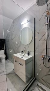a bathroom with a sink and a mirror at PG Luxury Apartment in Kavála