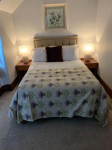 a bedroom with a large bed with a flowery bedspread at Advie Lodge in Inverness