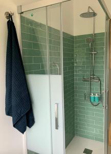 baño con ducha de azulejos verdes en Casa Frutales Escaselas, en Finisterre