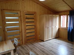 Zimmer mit Holzwänden, einem Tisch und einem Fenster in der Unterkunft Domek 2 w Rancho Żnin in Żnin