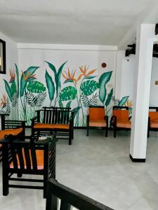 a room with chairs and a mural on the wall at Aprima Hotel in Kalutara