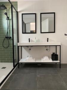 a bathroom with a sink and a shower with mirrors at Olive Boutique Guesthouse in Vila Franca do Campo