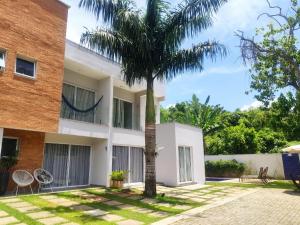 une maison avec un palmier devant dans l'établissement Casa de Condomínio em Maresias - Pertinho da praia, à Maresias