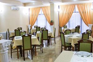a dining room with tables and chairs and windows at RHC Royal Hotel in Oradea