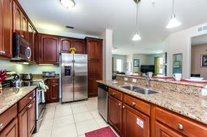 a kitchen with wooden cabinets and a stainless steel refrigerator at Treasure Palace in Orlando