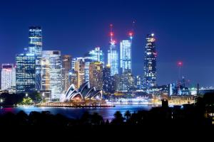 une ligne d'horizon de la ville avec l'opéra sydney la nuit dans l'établissement Roar And Snore, à Sydney