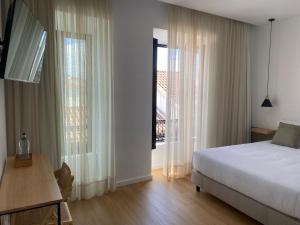 a bedroom with a bed and a large window at Olive Boutique Guesthouse in Vila Franca do Campo +37 photos