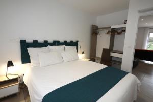 a bedroom with a large white bed and a window at Gite les edelweiss Fleurs des Pyrénées in Argelès-Gazost