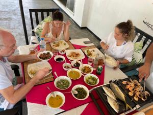 a group of people sitting at a table eating food at Aprima Hotel in Kalutara