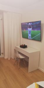 een kamer met een bureau en een televisie aan de muur bij Luksusowy Apartament Nad Zalewem in Serock