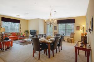 a dining room and living room with a table and chairs at Beautiful Condo at Vista Cay Resort Near WDW in Orlando