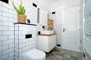 La salle de bains blanche est pourvue de toilettes et d'un lavabo. dans l'établissement 4-star Apartments Bianco, à Kaštela