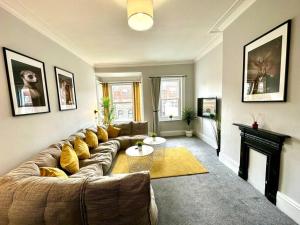 a living room with a couch and a fireplace at Massive 4 bedroom Duplex Apartment - Sleeps up to 10 People - Free Parking - 5 Minutes to the Best Beach! - Great Location - Fast WiFi - Smart TV - Newly decorated - sleeps up to 10! Close to Bournemouth & Poole Town Centre & Sandbanks in Bournemouth