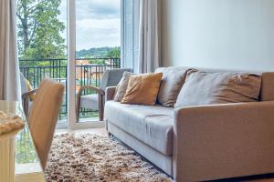 a living room with a couch and a balcony at Vista do Vale! 400 metros da Rua Coberta - Acomoda até 4 hóspedes in Gramado
