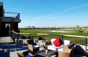balkon z kanapą i krzesłami na polu golfowym w obiekcie Roda Golf & Beach Resort, Murcia w mieście Roda
