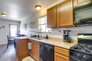 a kitchen with wooden cabinets and a sink and a stove at Cozy Colorado Retreat with Patio, Grill and Fire Pit! in Alamosa