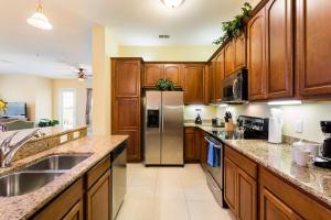 eine Küche mit Holzschränken und einem Kühlschrank aus Edelstahl in der Unterkunft Florida Palms in Orlando