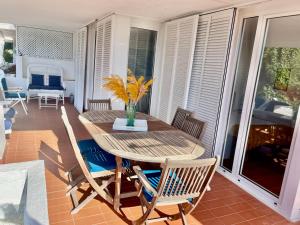 ブラナスにあるSeaHomes Vacations - MARINA BLUE in a exclusive placeの木製テーブルと椅子付きのポーチ