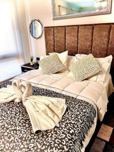 duże łóżko w sypialni z lustrem w obiekcie Apart Hotel en Centro de Santiago. Casco Historico w mieście Santiago