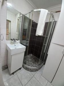 a bathroom with a shower and a sink at Royal Classico Getaway in Strand Beach in Cape Town