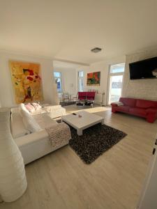 ein Wohnzimmer mit einer weißen Couch und einer roten Couch in der Unterkunft feelgood Apartments - Apartment Esclusivo - wohnen auf Zeit möblierte Wohnung in Braunschweig