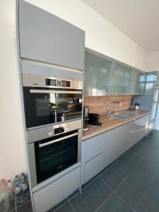 a kitchen with stainless steel appliances and a sink at feelgood Apartments - Apartment Esclusivo - wohnen auf Zeit möblierte Wohnung in Braunschweig