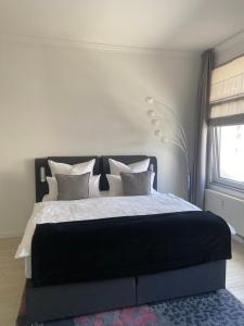 ein Schlafzimmer mit einem großen Bett mit weißer Bettwäsche und Kissen in der Unterkunft feelgood Apartments - Apartment Esclusivo - wohnen auf Zeit möblierte Wohnung in Braunschweig
