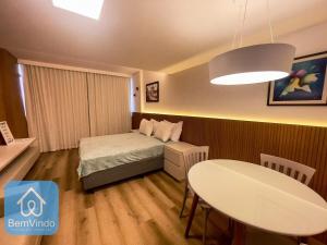 a small bedroom with a bed and a table at Apartamento completo com píer e acesso ao mar 4 in Salvador