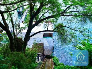 a train is coming down the tracks next to the water at Apartamento completo com píer e acesso ao mar 4 in Salvador