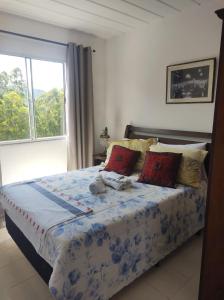 - une chambre avec un grand lit et une fenêtre dans l'établissement Pedra Do Imperador, à Nova Friburgo