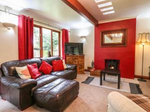 a living room with a leather couch and a fireplace at Amberleigh in Oakham