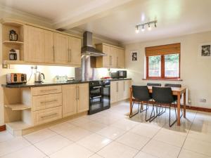 a kitchen with wooden cabinets and a table and chairs at Amberleigh in Oakham