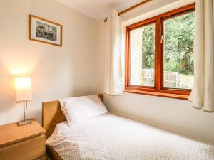 ein kleines Schlafzimmer mit einem Bett und einem Fenster in der Unterkunft Amberleigh in Oakham
