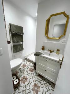 a white bathroom with a sink and a mirror at Studio Patchouli - Centre historique - Climatisation - WiFi in Grasse