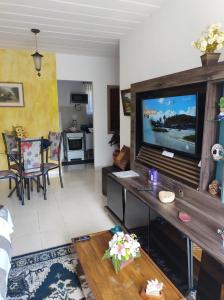 een woonkamer met een grote flatscreen-tv bij Pedra Do Imperador in Nova Friburgo