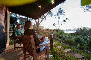 a man and a woman sitting in chairs under a tent at Roar And Snore in Sydney